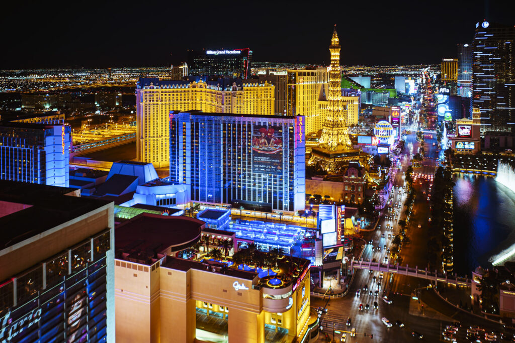 A stunning night view of the Las Vegas Strip, featuring iconic casinos like Bally’s and Paris Hotel, showcasing Nevada’s vibrant tours and cityscape.